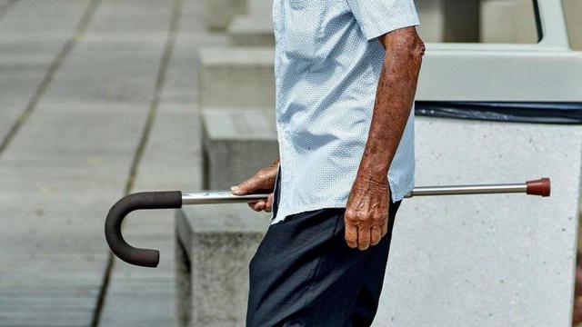 Old person holding a cane.