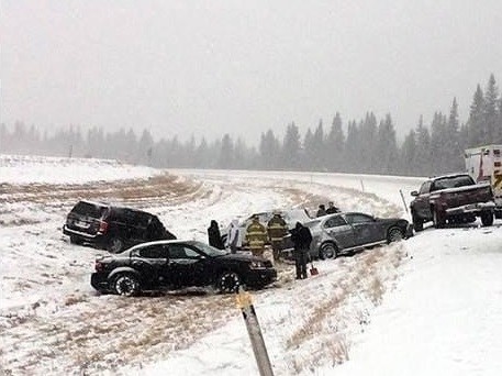 snowy road with cars in ditch