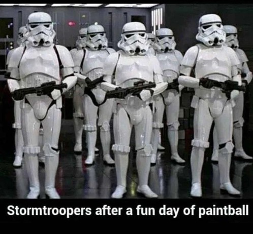Squad of armed stormtroopers in pristine armour facing the camera. Text reads: Stormtroopers after a fun day of paintball.