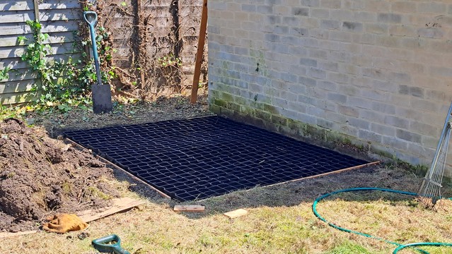 A small patch of dug land, with a plastic shed base