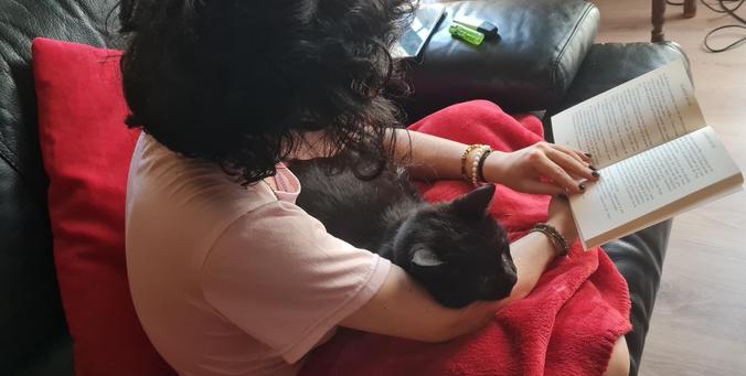 Chat noir câlinant unz fille qui lit