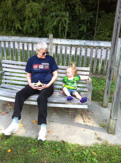 Photo from 2012 in which my mother and my daughter share a moment on a swinging bench at a park.