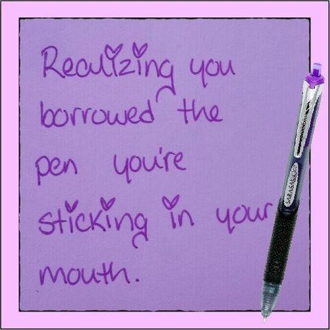 A hand written note on purple paper, the pen is placed to the right hand side, the cursive writing reads:
Realising you borrowed the pen you're sticking in your mouth