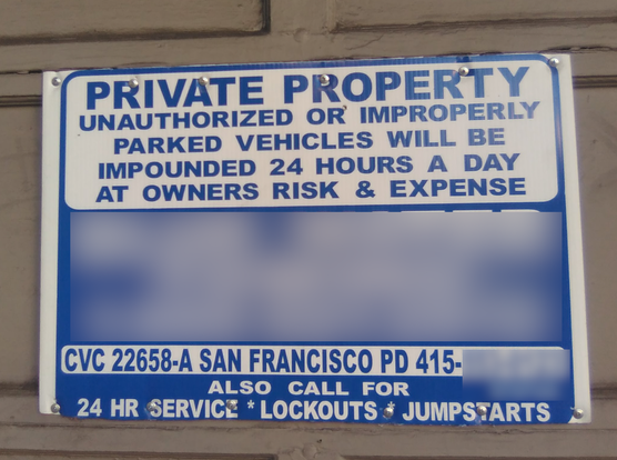 Sign on a garage door. Sign reads: private property. unauthorized or improperly
parked vehicles will be impounded 24 hours a day at owners risk & expense. [redacted] 
CVC 22658-a San Francisco PD 415-[redacted]
also call for 24 hr service, lockouts, jumpstarts