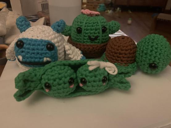A cactus, yeti, turtle, and two peas in the pod crocheted by Nyla.