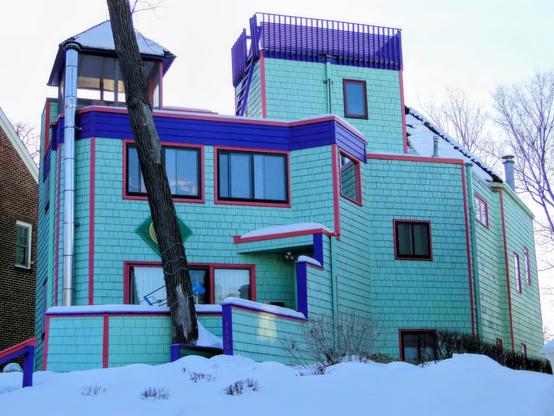 James Stageberg created many unique modernist houses, this is one of his best.  Ladders, widow's walk, not very many square corners or right angles to it.   All done in aqua blue walls, purple and crimson trim, the windows framed in red and black.