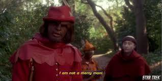 Worf, dressed in red, standing in the woods and saying, 