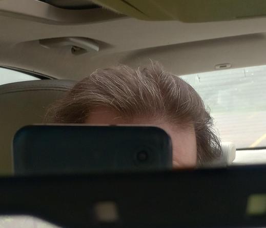 My hairline in the rear view mirror. Random gray hairs are prominent.