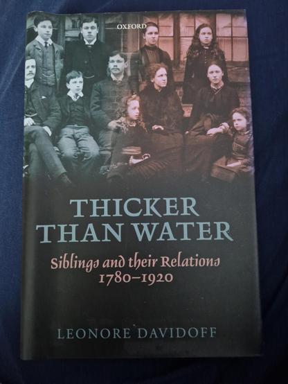 Hardback of Thicker Than Water: Siblings and their Relations 1780-1920 by Leonore Davidoff. The cover features a photo of a large Victorian family of five young men and six young women.