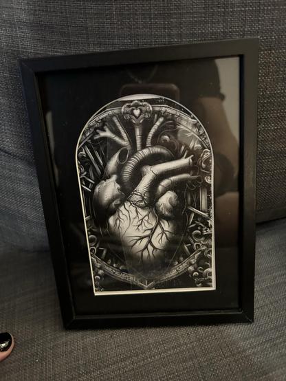 Gerahmtes Schwarz-Weiß-Kunstwerk eines anatomischen Herzens mit komplizierten Details, das auf einem dunklen Hintergrund ruht.