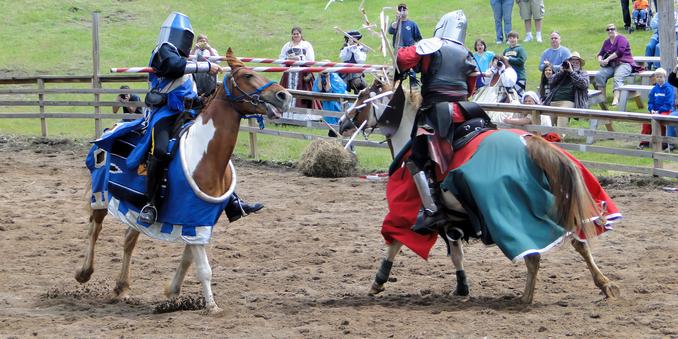 Von links: Ein behelmter Ritter in Blau galoppiert nach rechts und schwingt eine Lanze, die den Schild eines anderen Ritters trifft und beim Aufprall zerbricht (aus Sicherheitsgründen ist es eine Tricklanze) – ein weiterer Ritter in Blau und Rot reitet von rechts.

Eine kleine Menschenmenge schaut im Hintergrund zu.