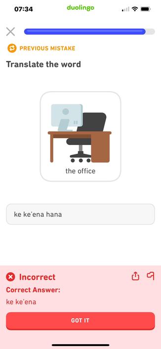 Screenshot from Duolingo. The lesson prompt is a cartoon image of a brown desk with a silver and gray computer monitor on top; a black office chair with three wheels is visible behind it. Lesson prompt text: “the office.” I have answered “ke keʻena hana” but at the bottom is the judgement “Incorrect! Correct answer: ke keʻena” in a bright red box!