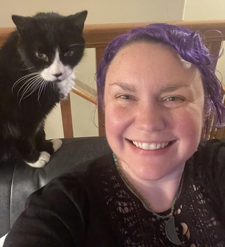 Selfie, I’m being photobombed by my tuxedo cat who is standing on the back of the chair behind me