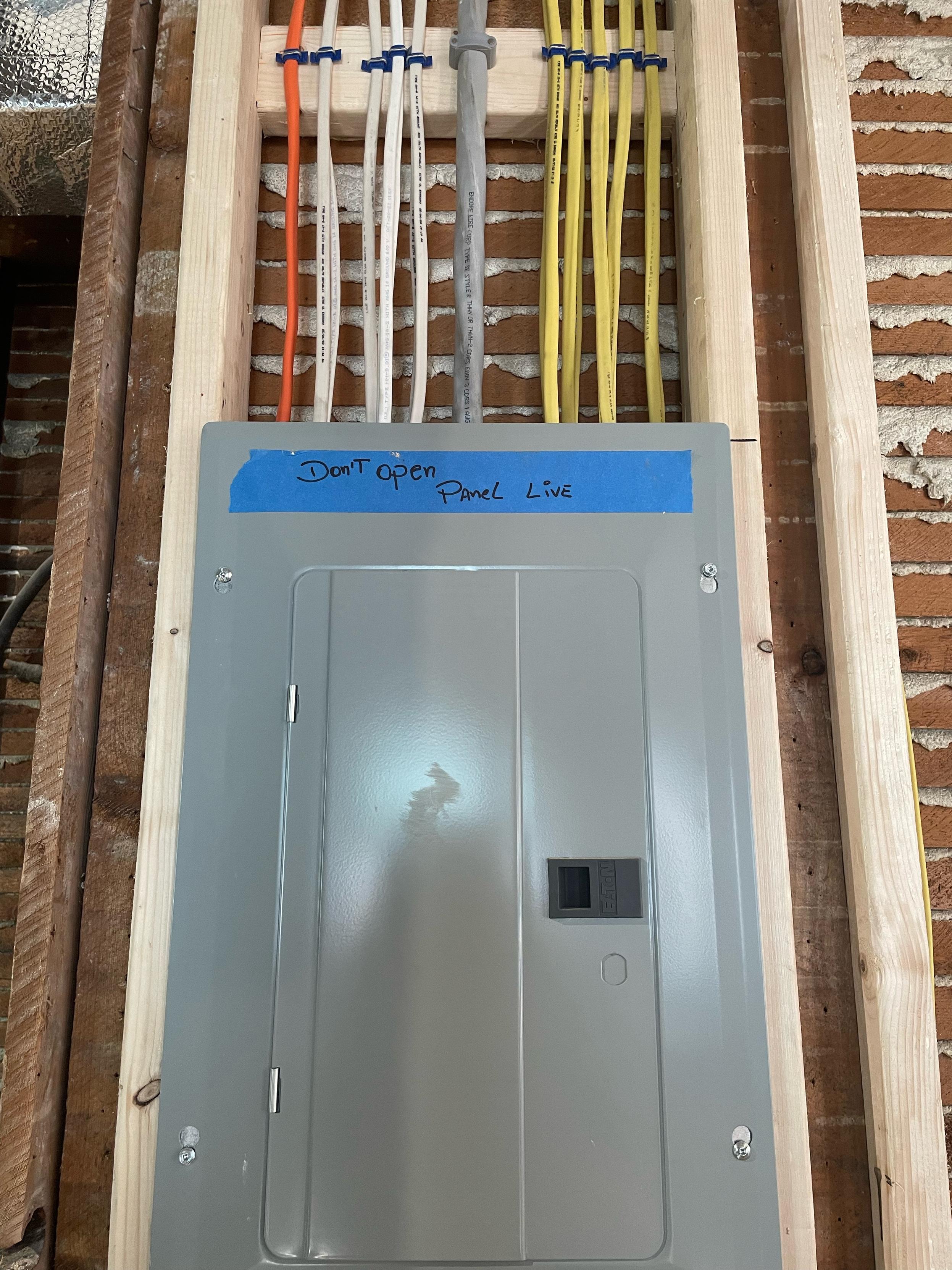 An electrical subpanel set into wood framing (no drywall). Wires come out the top, almost dead vertical and parallel. They are fastened to the framing and organized by color. It’s so satisfying.