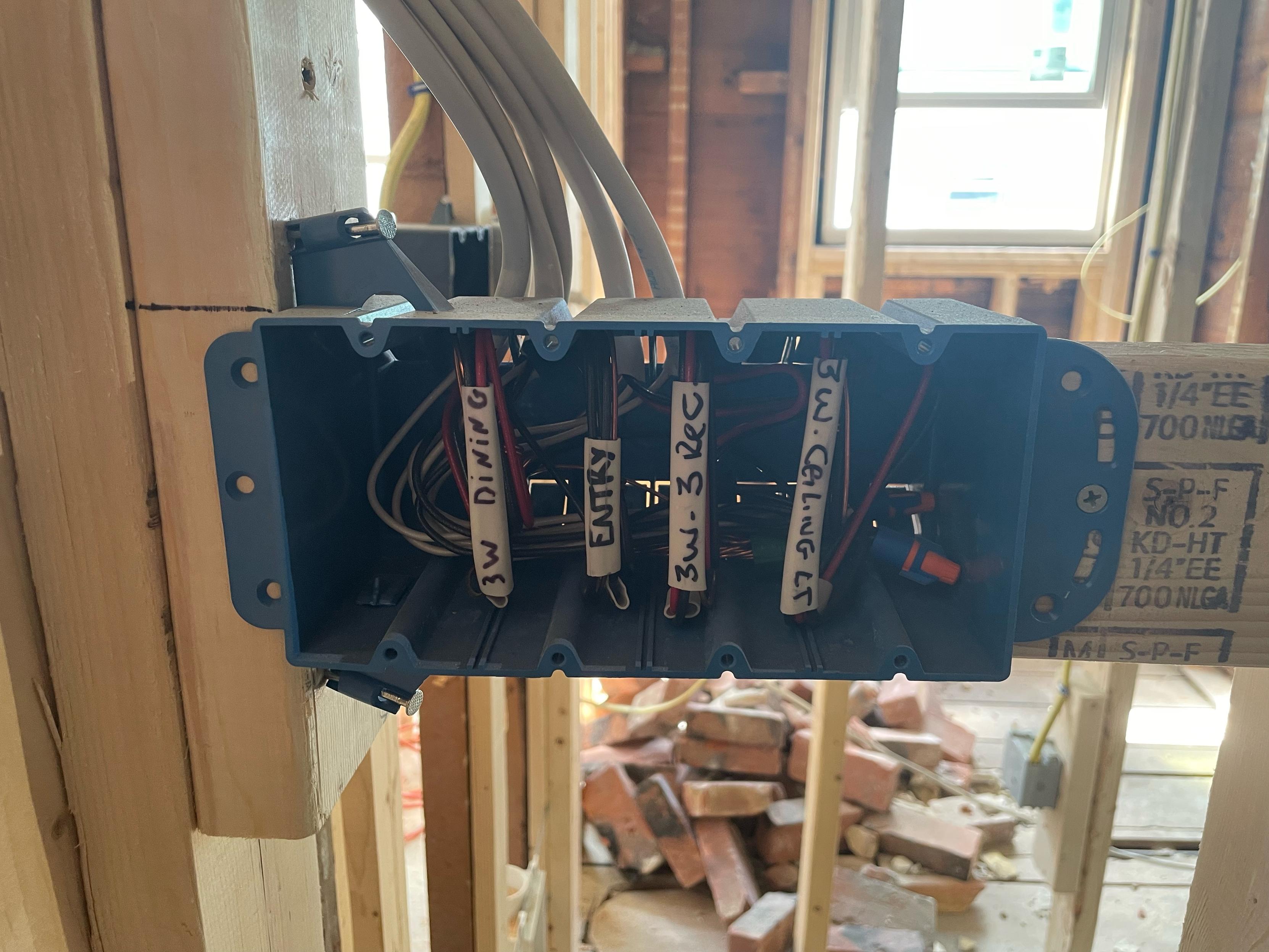 The inside of a light switch, set into wood framing (there is no wall yet). The wires are labeled. LABELED!!!