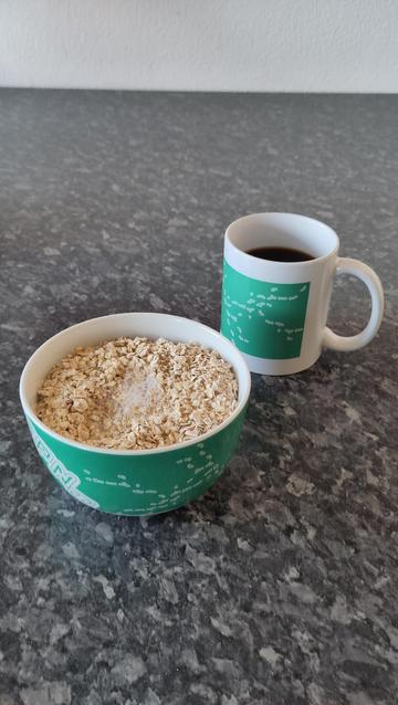 Müslischüssel und eine Tasse Kaffee mit dem Logo der Gulaschprogrammiernacht aus dem Jahre des Herrn 2024.