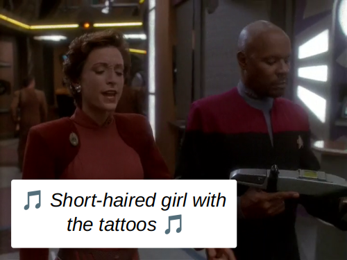 Kira Nerys and Benjamin Sisko walk in the middle of a spot on the lower level of the promenade on Deep Space 9. Ben is holding a Starfleet phaser rifle. Kira sings 