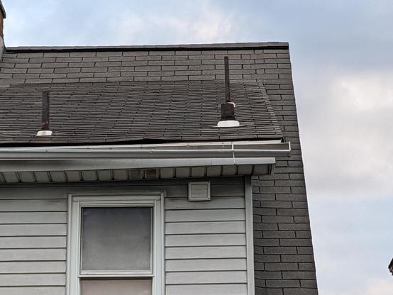 A photo of the back of my house, showing that the gutter at the right corner has come detached and is sagging