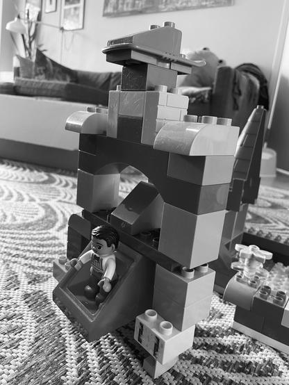 A blocky Duplo robot with a blocky Duplo person inside.