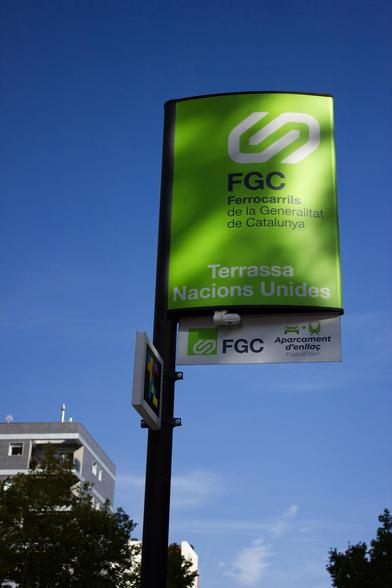 A green sign with the FGC logo (which represents a train coupler) on top and a text that reads 