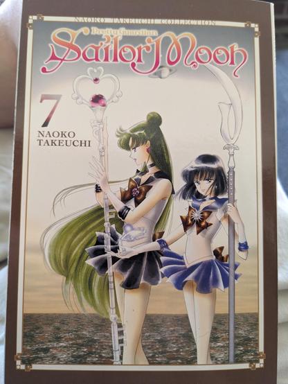 The cover of Volume 7 of the SAILOR MOON manga, showing Sailors Pluto and Saturn. The frame of the cover image is the brown of river water after five days of torrential rain. It is not becoming.