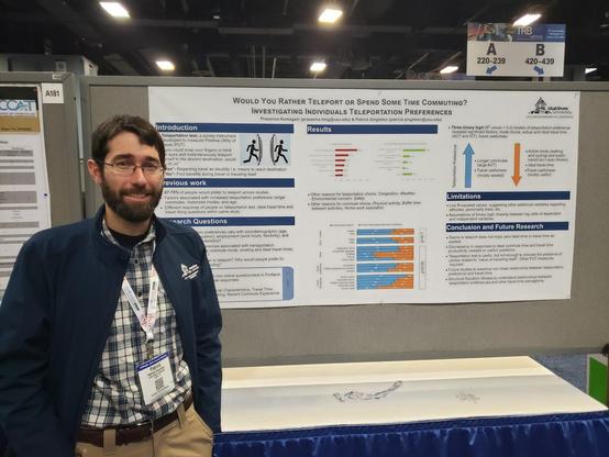 A youngish man standing in front of a poster "Would You Rather Teleport or Spend Some Time Commuting?  Investigating Individuals Teleportation Preferences"

The research was done by Prasanna Humagain (prasanna.hmg@usu.edu) and Patrick Singleton (patrick.singleton@usu.edu).

usu.edu is Utah State, Patrick Singleton (the youngish man) is the associate professor there.